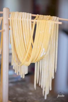 some noodles are hanging on a clothes line with wooden poles and string attached to it