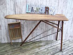 a wooden table sitting on top of a wooden floor next to a chair and sign