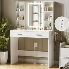 a white vanity with mirror and lights in a room next to a potted plant