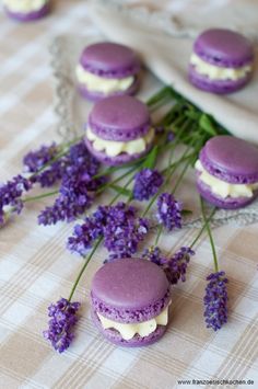 purple macaroons with white chocolate filling and lavender flowers on a tablecloth, ready to be eaten