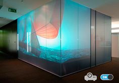 an empty room with glass partitions in front of the wall that has a photo of a sailboat on it