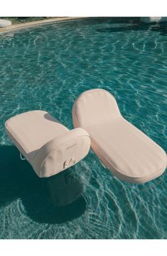 an inflatable mattress floating on top of the water next to a swimming pool