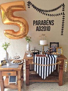 a table topped with desserts and balloons