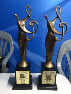 two trophies sitting on top of a white table