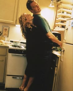 a man standing next to a woman in a kitchen