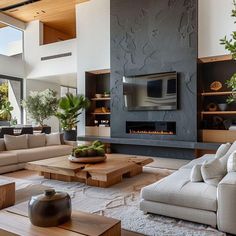 a living room with couches and tables in front of a fire place that is built into the wall