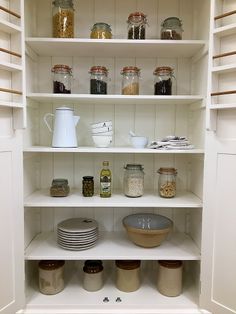 an open pantry filled with lots of food and condiments on top of white shelves