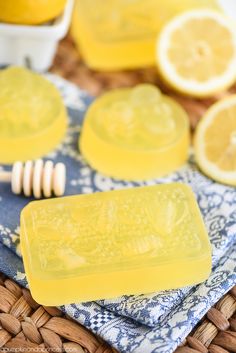 two soap bars sitting on top of a blue and white towel next to sliced lemons