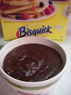 a bowl filled with chocolate pudding next to a box of bisquick french toast