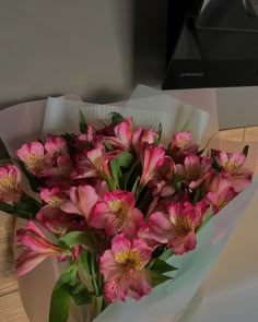 a bouquet of pink flowers sitting on top of a wooden table