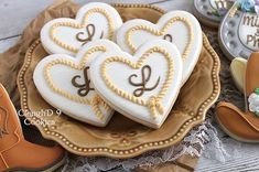 some cookies are on a plate with cowboy boots and other decorations in the shape of hearts