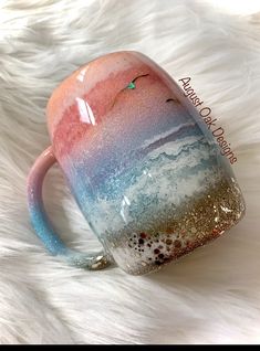 a colorful coffee mug sitting on top of a white fur