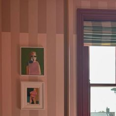 three pictures are hanging on the wall next to a window with pink and purple stripes