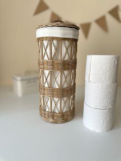 two rolls of toilet paper sitting next to each other on a white table with bunting flags in the background