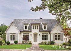 a white house with lots of windows and grass