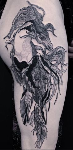 a woman's thigh with an artistic tattoo design on her leg and the image of a horse