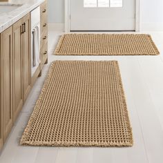 two rugs on the floor in a kitchen