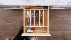 a kitchen cabinet with utensils and spoons in it