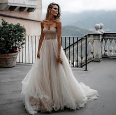 a woman in a wedding dress standing on a balcony