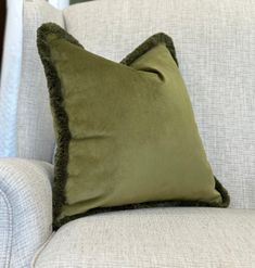 a green pillow sitting on top of a white couch