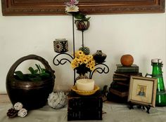 a table topped with vases filled with flowers next to framed pictures and other items