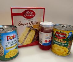 some food items are sitting on a table next to a box of cake mix and two cans of pineapple slices