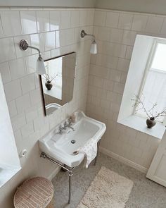 a white sink sitting under a bathroom mirror