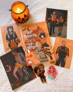 four halloween cards and a candle on a bed