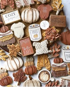 an assortment of fall cookies and treats on a table with autumn leaves, pumpkins, acorns and more