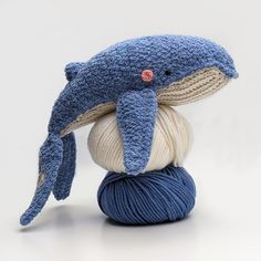 a ball of yarn with a stuffed dolphin on top