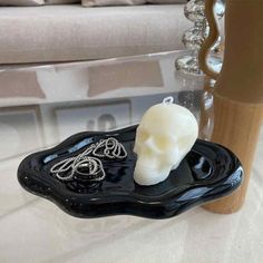 a black tray with a white skull on it sitting next to a glass coffee table