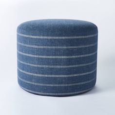 a blue striped ottoman sitting on top of a white floor