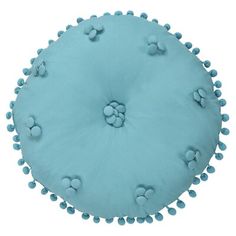 a blue round cushion with pom - poms on it