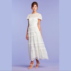 This Wedding Dress, Cut In A Lovely Lace, Is Designed With A High Neckline-Cap Sleeve Illusion, Paillette-Accented Fringe, A Fitted Bodice That Flows Into A Full Tiered Skirt, And A Delicate Scallop Lace Hem. Its Inherent Ease Makes It A Wonderful Choice For A Ceremony With A Natural Setting, Such As An Intimate Backyard Wedding. A Concealed Zip Closure Delivers A Fit That Feels Like It Was Made For You. " Approx. Length From High Point Shoulder To Hem Is 46 1/2"" Measurements Are Taken From Siz White Dresses With Fitted Bodice For Reception, White Fitted Bodice Dress For Reception, White Dress With Fitted Bodice For Reception, White Floor-length Dress For Reception, White Maxi Length Dress For Reception, White Maxi Dress For Reception, Scalloped Lace Dress With Fitted Bodice For Ceremonies, Ceremony Dress With Scalloped Lace And Fitted Bodice, Elegant White Dress For Reception