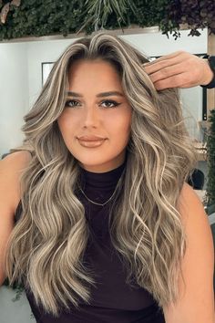 This hairstyle features a seamless balayage technique, blending cool blonde highlights smoothly into a darker base to create a natural-looking, sun-kissed effect. The long sections are styled into loose curls, adding movement and dimension that further bring out the three-dimensional color. It provides a low-maintenance look that's both - Click to see more of Get Inspired by these 32 Stunning Balayage Hair Looks and follow us for more hairstyle ideas. // Photo Credit: Instagram @orkunbaykut Partial Foil Highlights Brunette To Blonde, Hair Dye Ideas Highlights, Blonde Before And After, Cool Tone Blonde Highlights, Long Blonde Hair Balayage, Low Maintenance Blonde Hair Balayage, Blonde Balayage On Dark Hair, Dimensional Blonde Balayage, Seamless Balayage