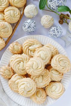 some cookies are on a white plate next to other desserts