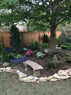 a stone bench sitting in the middle of a garden