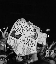 many people are holding up signs in the air