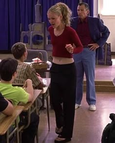 a woman standing in front of a classroom full of students