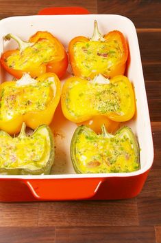 several peppers in a red casserole dish on a wooden table