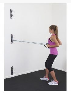 a woman is using a pull up bar to do exercises on the floor in front of a white wall