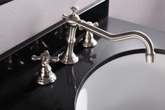 a bathroom sink with chrome faucet and black countertop