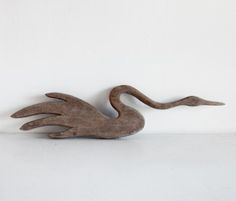 a wooden sculpture of a bird on a white background