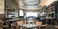 a restaurant with tables and chairs in front of a clock on the wall above them