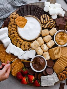 a platter filled with cookies, marshmallows, and other desserts