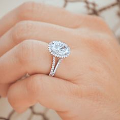 a woman's hand holding an engagement ring with a diamond in the middle and side