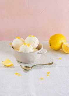 a bowl filled with ice cream next to two lemons