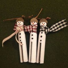 three snowmen made out of toothpicks sitting on the ground