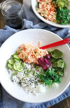 two white plates filled with rice and veggies on top of a blue towel