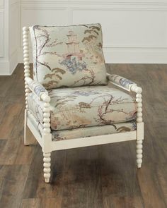 a white chair sitting on top of a hard wood floor next to a wall and window